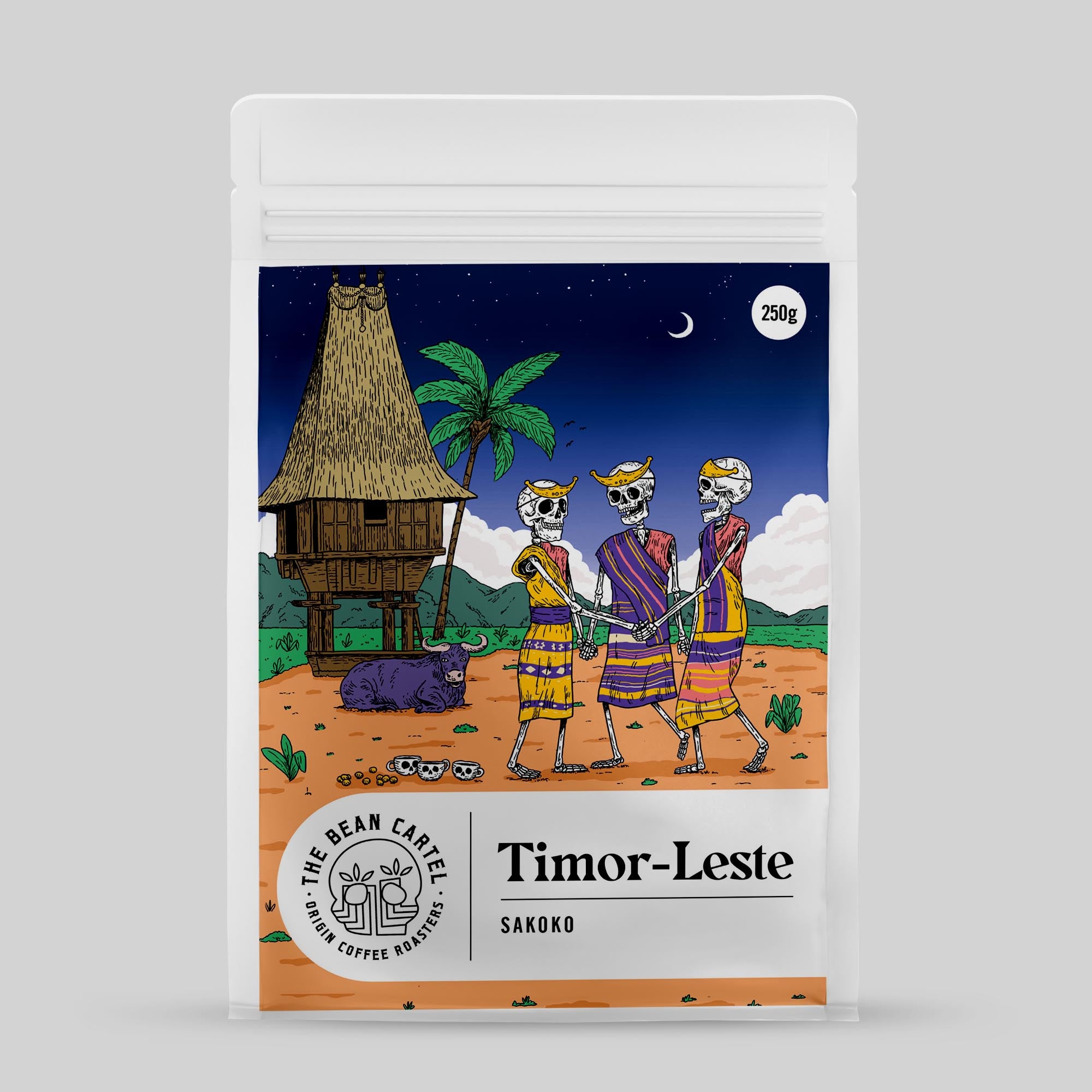 Single Origin Coffee package with cartoon skeletons and traditional building design, featuring 'Timor-Leste' and 'The Bean Cartel' branding.